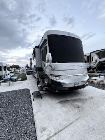 Freshly washed Class A motorhome at dusk, front and driver side
